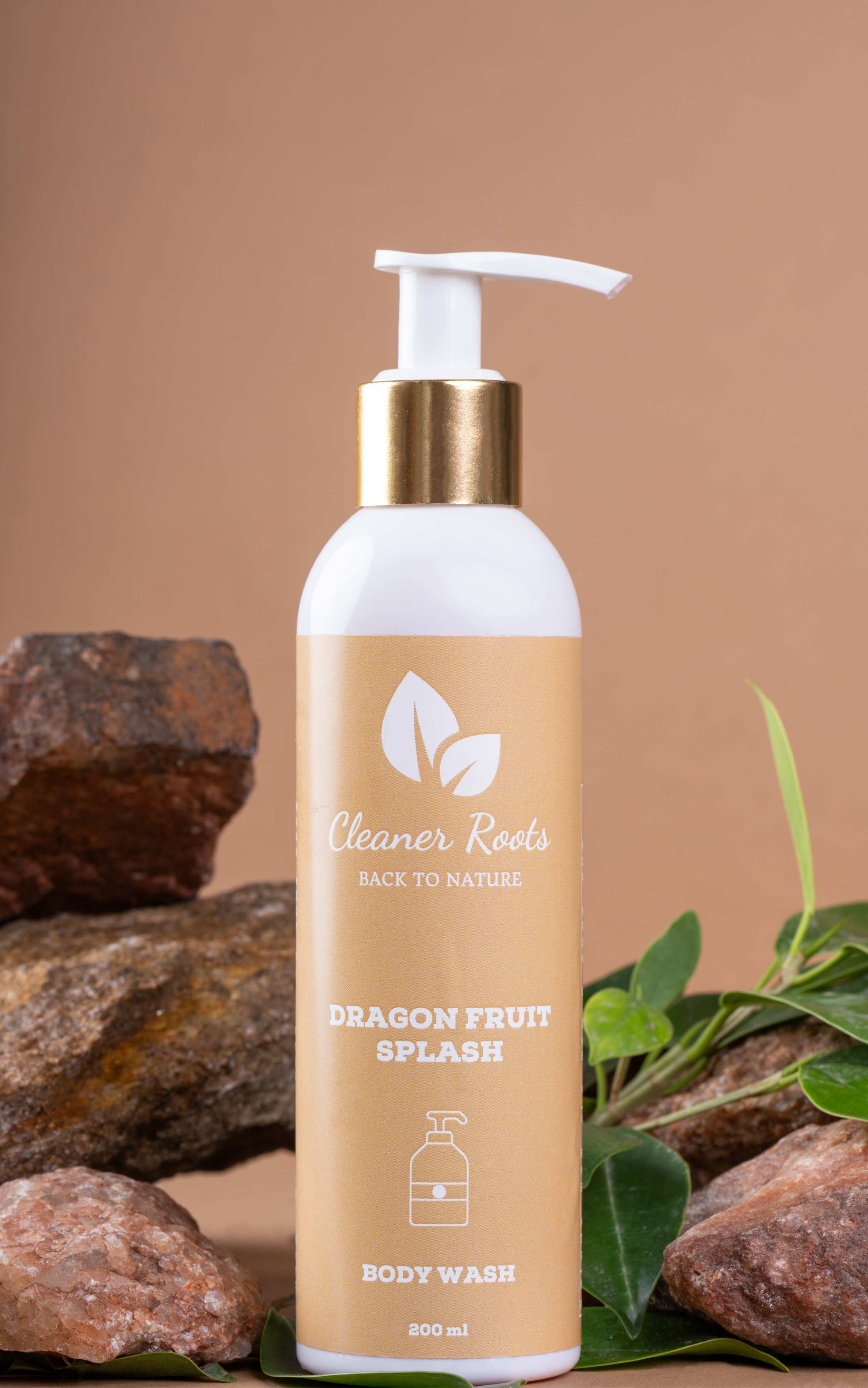 Cleaner Roots Dragon Fruit Splash Body Wash tilted on natural stones and green leaves - cleanser for glowing skin, paraben-free body wash, uplifts body & mind.