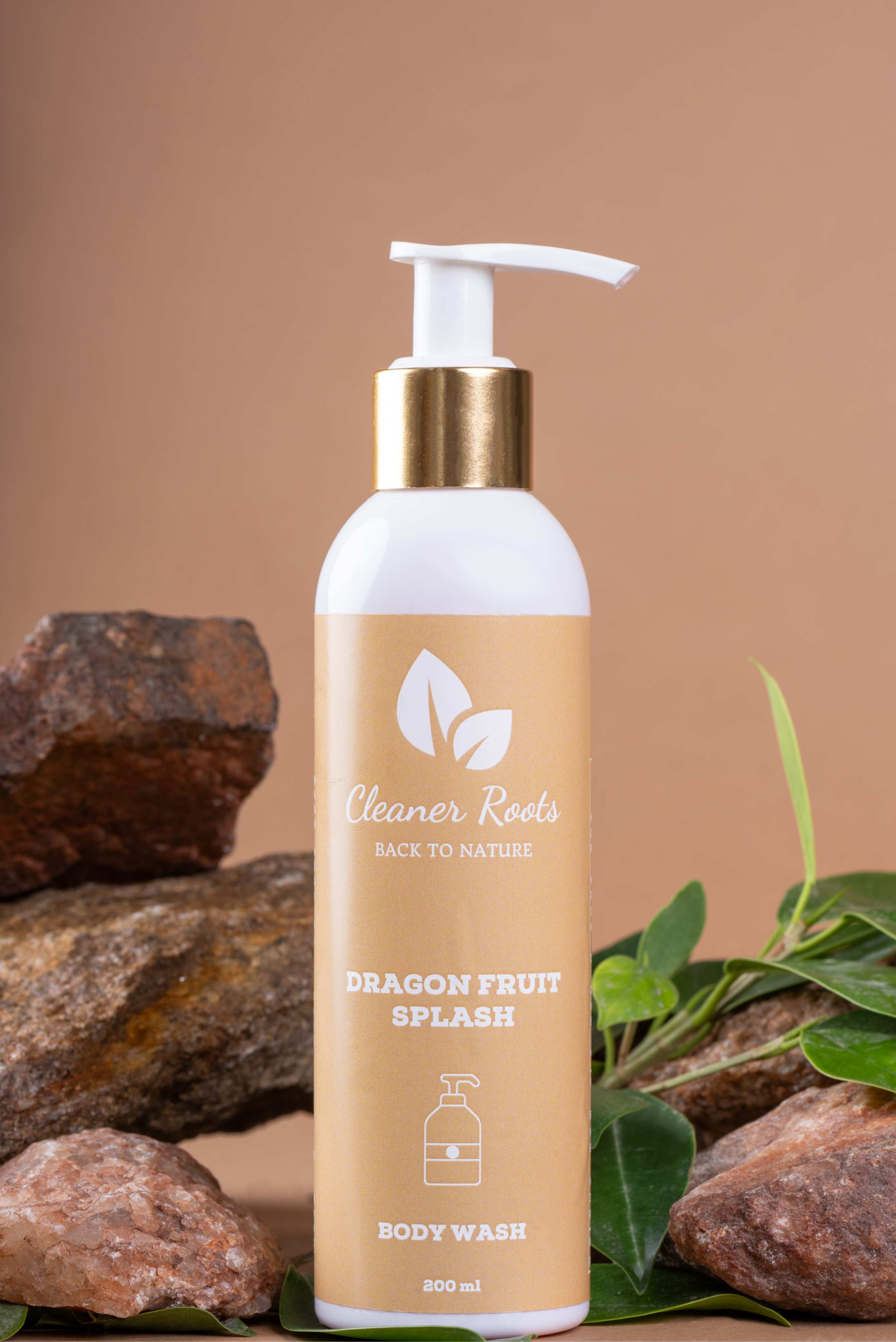 Cleaner Roots Dragon Fruit Splash Body Wash tilted on natural stones and green leaves - cleanser for glowing skin, paraben-free body wash, uplifts body & mind.