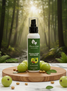 Bottle of 'Cleaner Roots' body elixir with green fruits on a wooden board in a forest setting