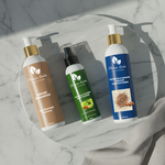 Three bottles of 'Cleaner Roots' hair care products on a marble surface.