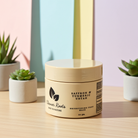 Beige jar with black text on a wooden surface with plants in the background